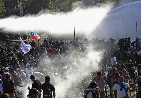 Demonstrators run from police launching water cannons and tear gas in Santiago https://www.hrw.org/ © 2019 AP Photo/Esteban Felix Demonstrators run from police launching water cannons and tear gas in Santiago © 2019 AP Photo/Esteban Felix